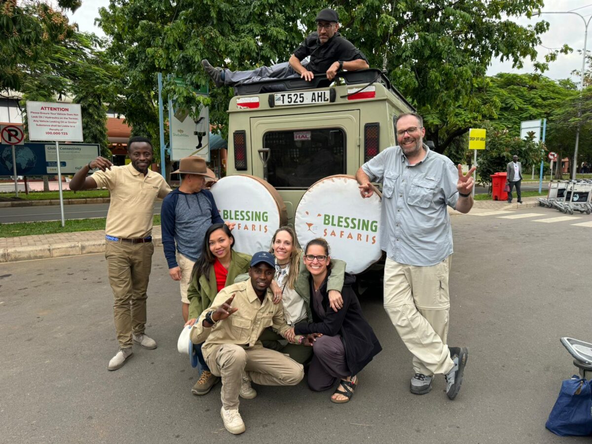 clients pausing for a photo after safari in Tanzania